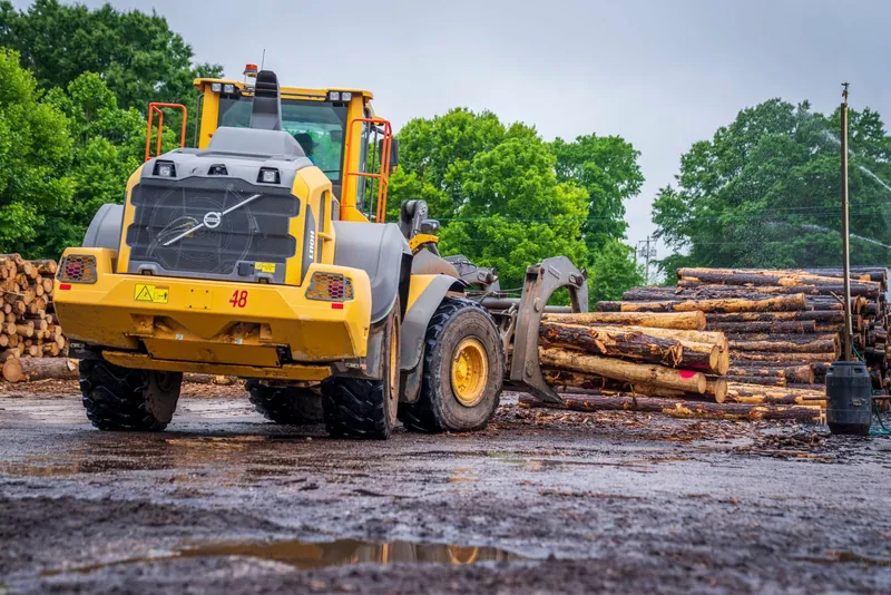 Gabe's Tree Service loader clearing logs during a lot-clearing job